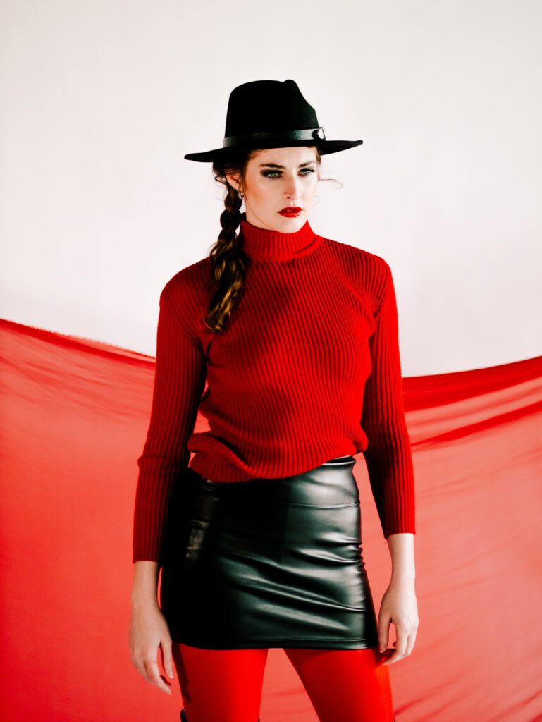 fashion-forward brand portrait with bold red and black styling and wide-brim hat