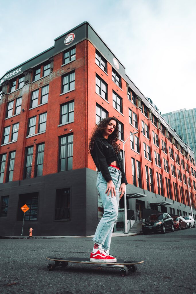 entrepreneur standing on skateboard in front of red-brick urban building in Portland