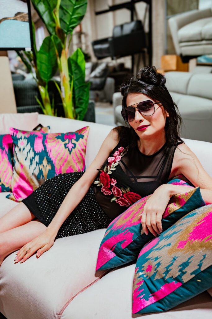 Indoor branding photo on printed couch with bold styling and sunglasses.