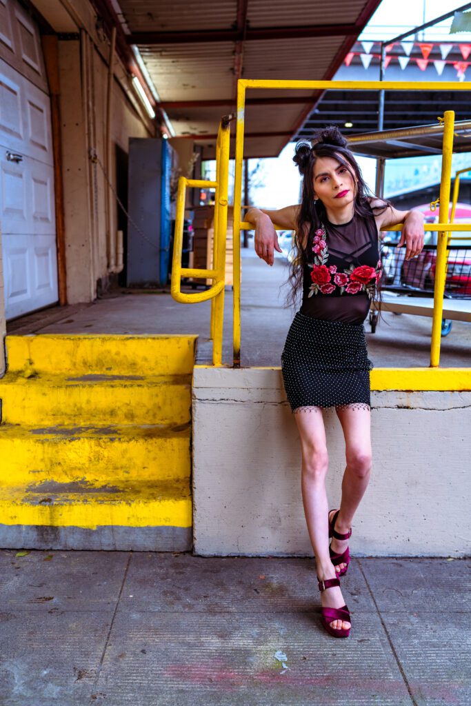 Industrial backdrop with bright yellow railing and confident branding pose.