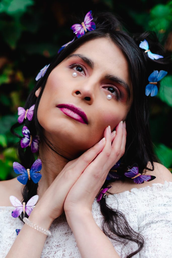 Creative brand photo of a woman with pearl accents and butterflies in her hair, captured during a dreamy pastel editorial session in Portland