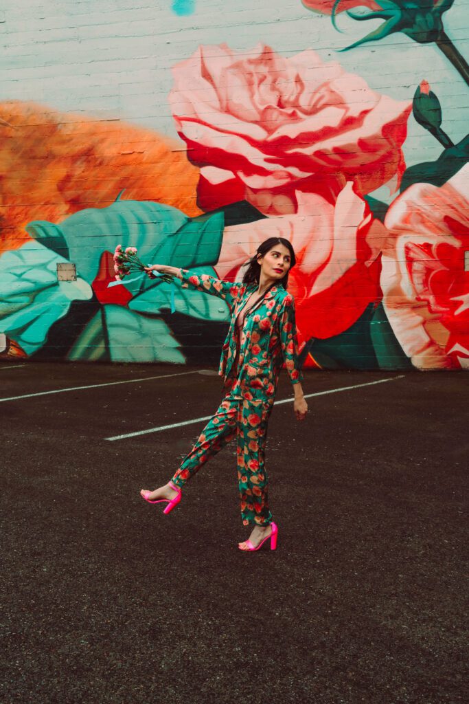 Candid fashion-forward brand shot against mural, showing energy and charm.
