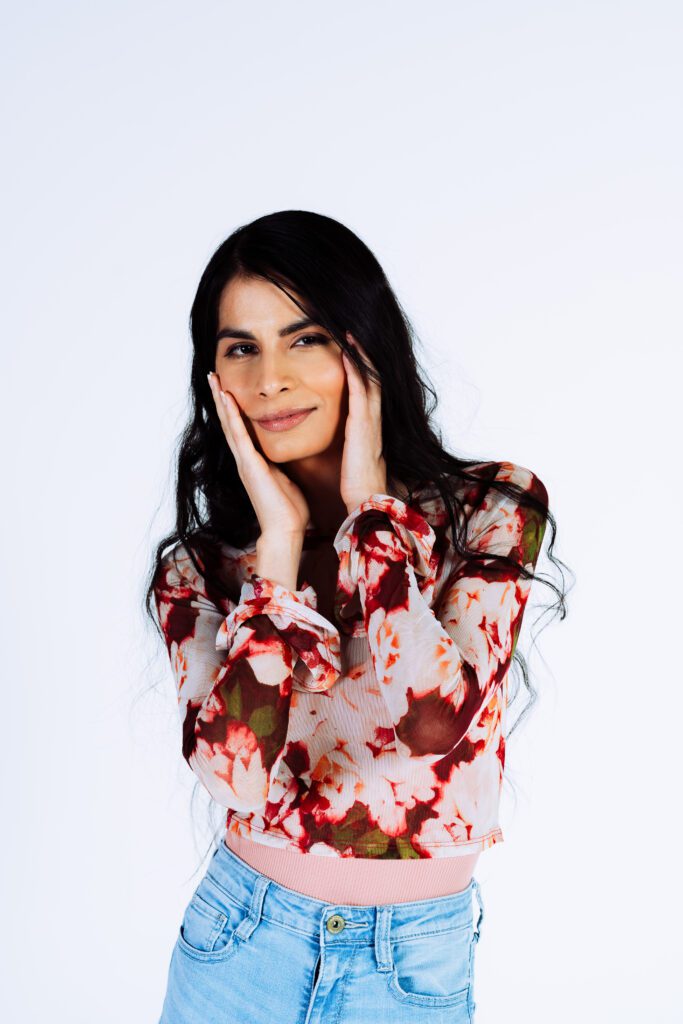 Studio portrait with hand-to-face pose and soft smile, perfect for actor and creative entrepreneur portfolios.