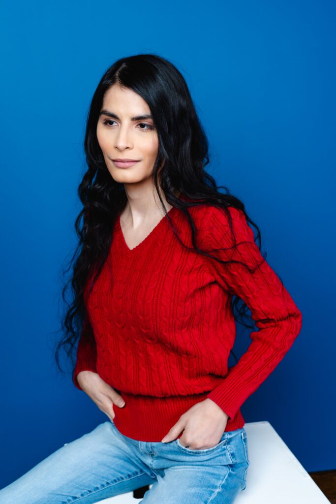 Minimal branding photo with a relaxed seated pose and bold color backdrop.