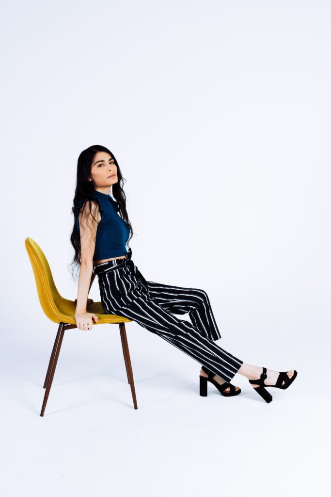 Editorial portrait on a mustard yellow chair, styled for modern creatives.