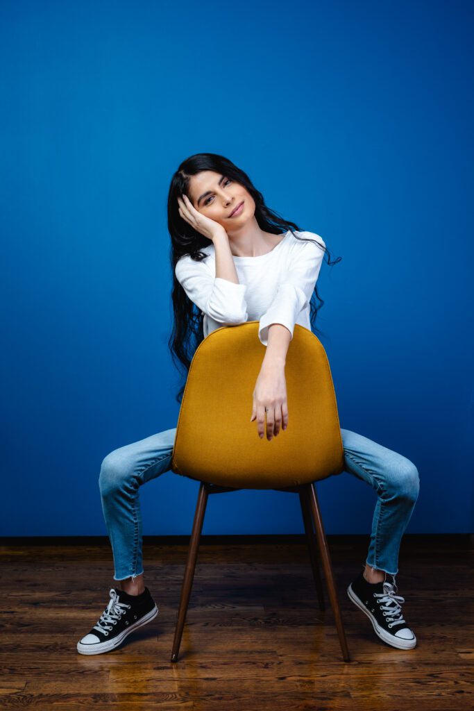 Creative personal brand photo featuring casual denim and sneakers in a bright, modern studio.