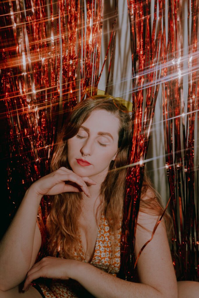 dreamy indoor portrait with golden light and red metallic streamers for bold branding