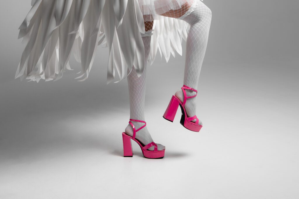 Detail image of bright pink platform heels with white fishnet tights, part of a fashion-forward monochrome branding session in Portland studio