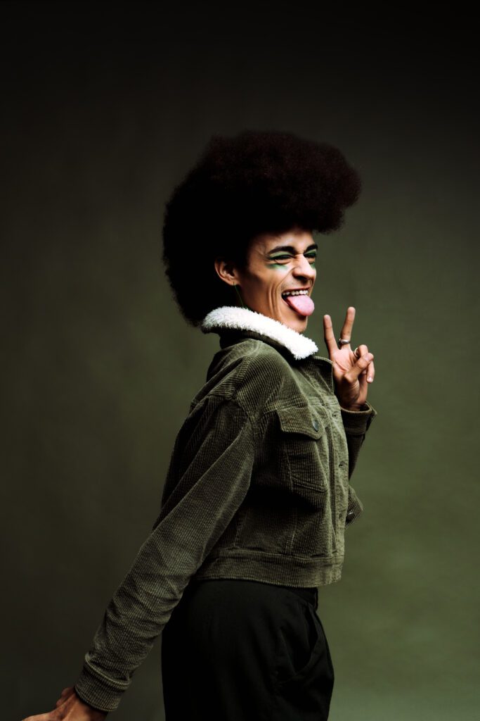 Full-body creative portrait in sage green jacket with motion pose, studio shoot in Portland