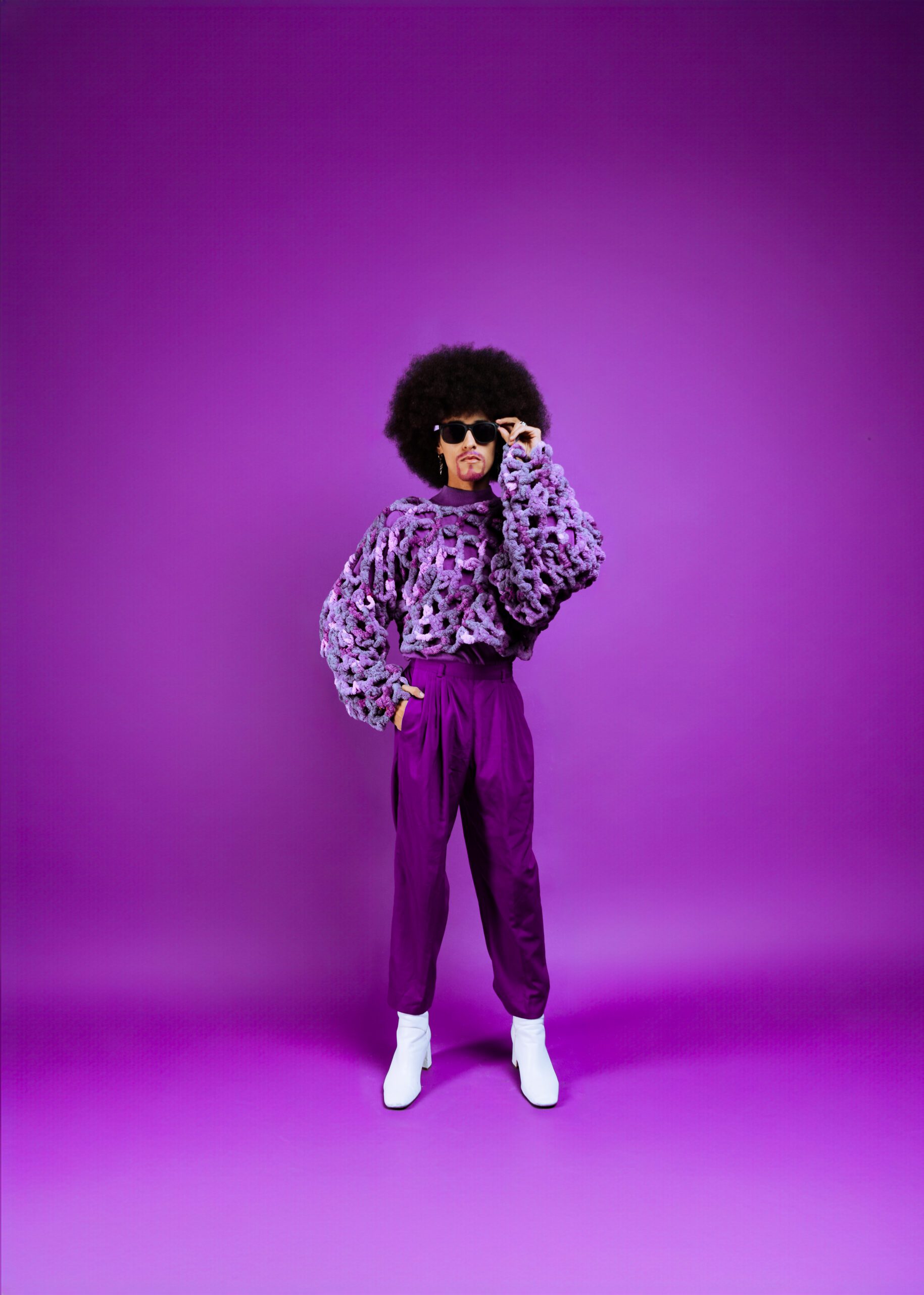 Full-body monochrome purple studio portrait of a creative artist in textured knitwear and sunglasses during a Studio Lab session at Cobalt Studios PDX by Mewphotovideo