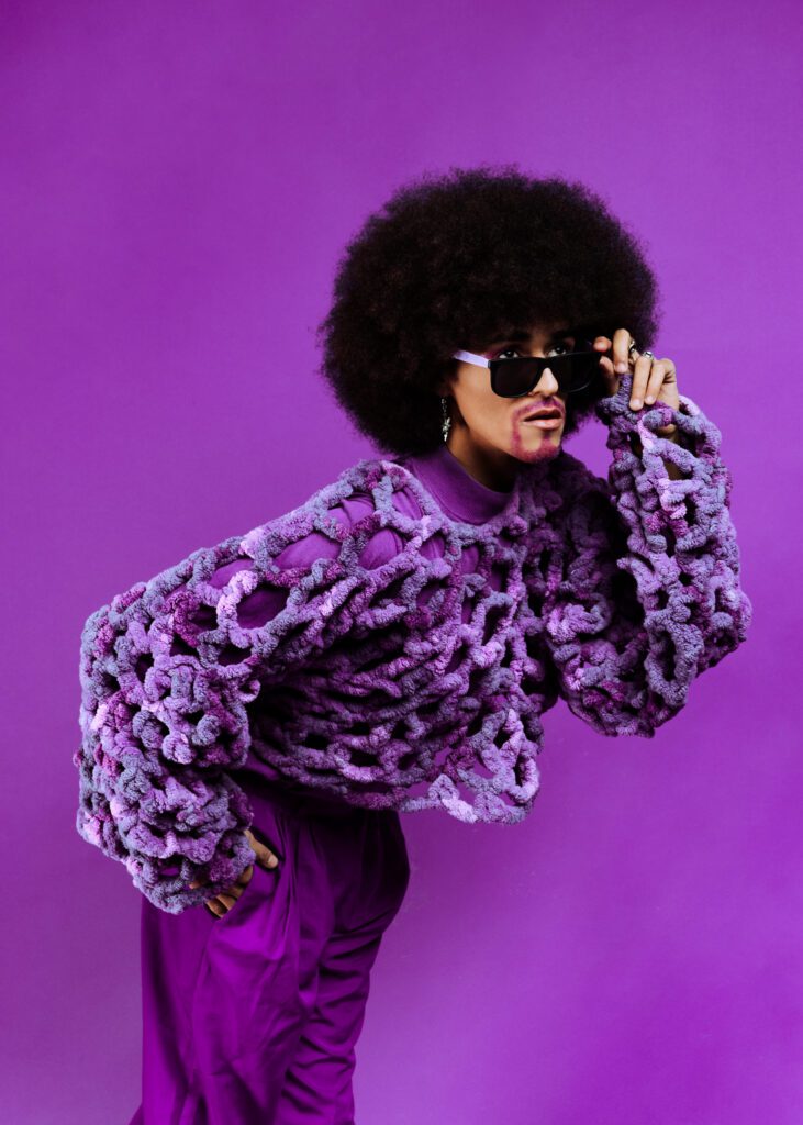 Close-up creative portrait of an artist in purple knitwear and sunglasses during a colorful Studio Lab session in Portland