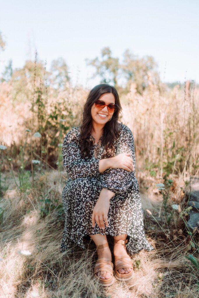 Full body portrait of a musician smiling in a field during a sunny outdoor branding session in Oregon