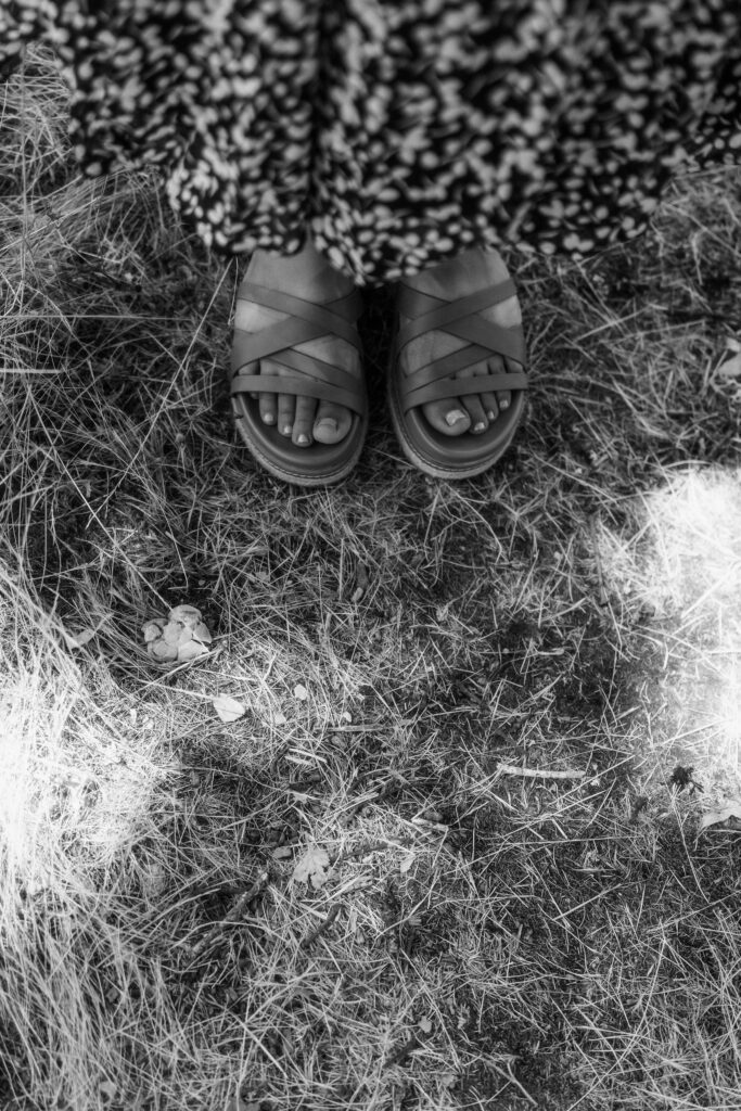 lose-up detail of artist’s sandals in the grass, captured during an outdoor creative branding session in Oregon