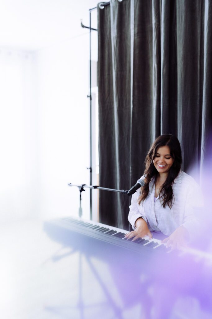Singer-songwriter playing keyboard in soft haze lighting during a Portland brand photography session