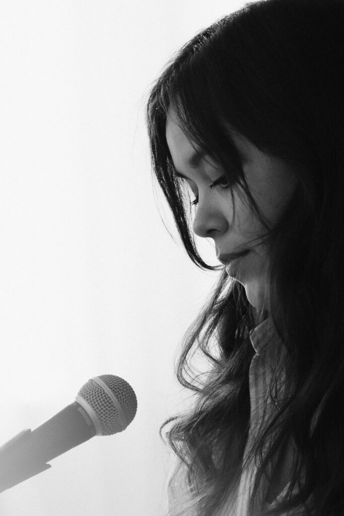 Black and white profile of a singer at the microphone captured in a quiet moment during a Portland brand shoot