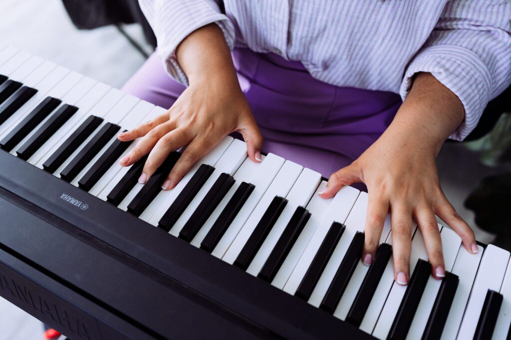 Close-up of hands playing a keyboard piano, shot as part of a creative identity-driven brand session for a musician in Speak Your Language by Mewphotovideo