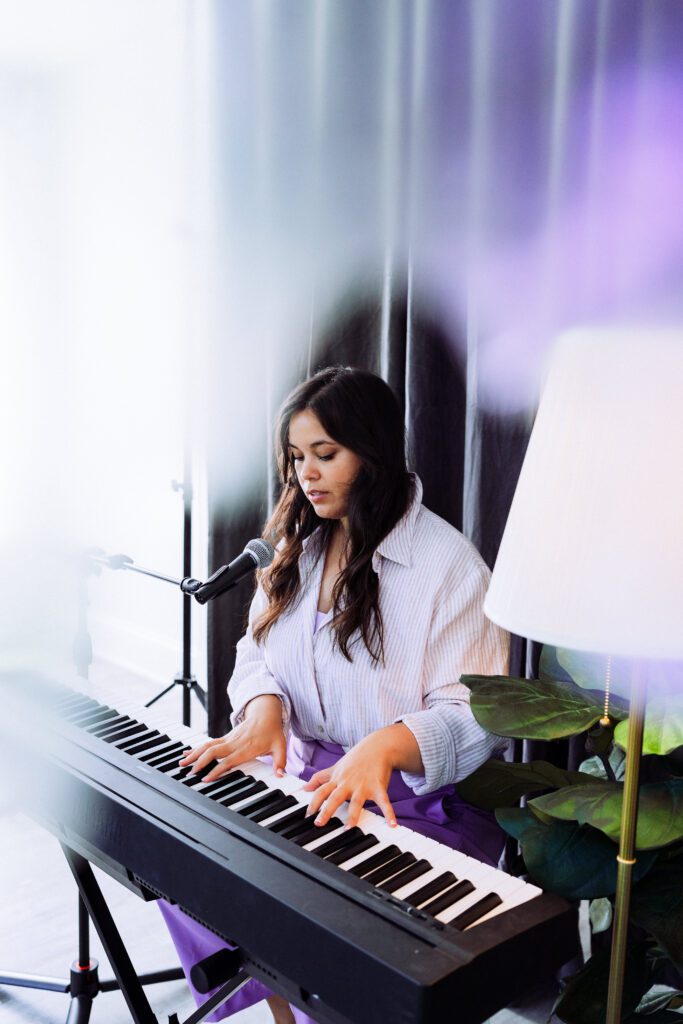 Musician performing at keyboard with dreamy purple haze during a Portland musician brand session