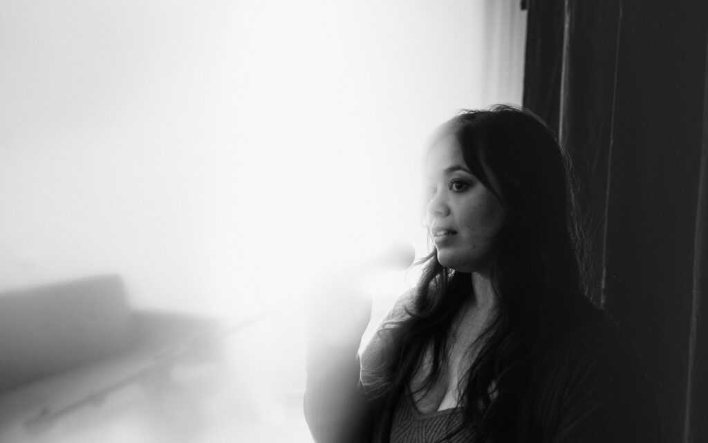 Black and white side portrait of a music artist in studio lighting during creative brand shoot