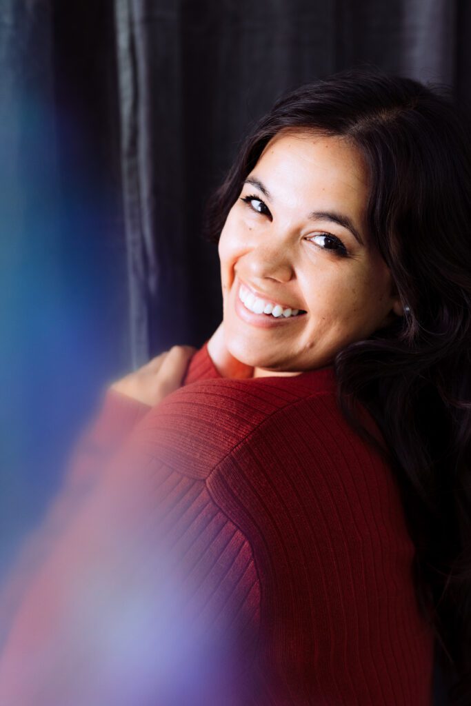 Musician smiling in soft rainbow haze light during a creative studio branding shoot