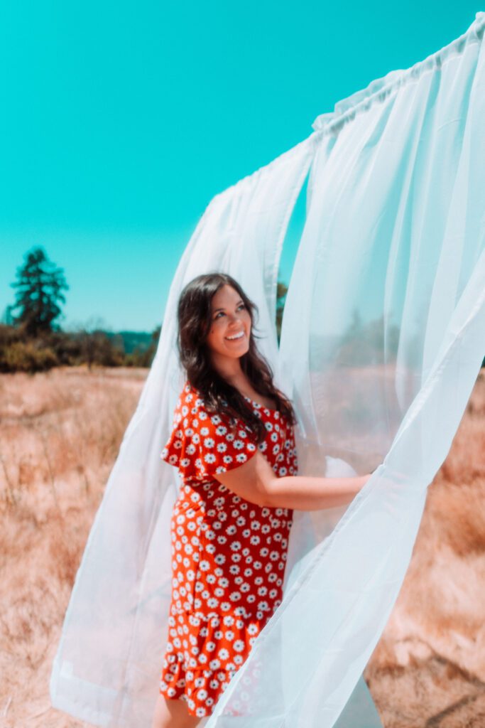Playful creative portrait of a musician with sheer white curtains in a branding session near Portland