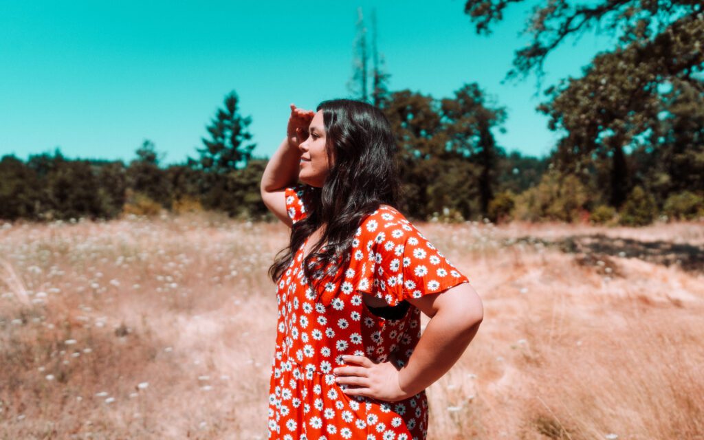 Musician standing in a field with confident pose and sunglasses during a sunny outdoor branding shoot