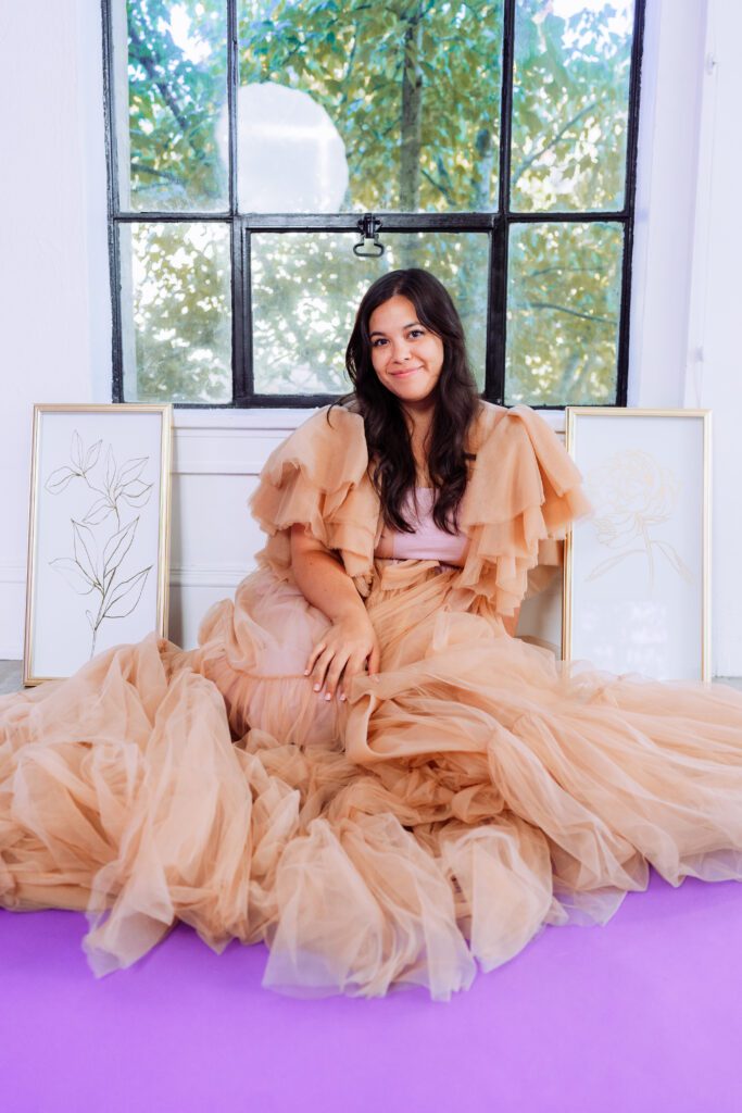 Full-length brand photo of a singer in tulle dress during a window-lit session at a Portland creative studio