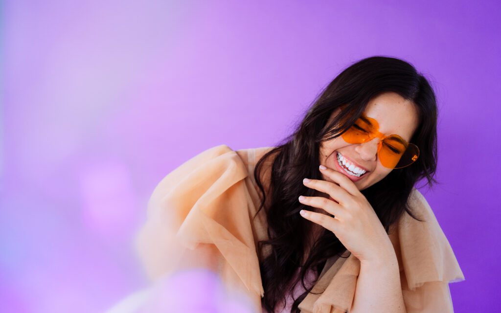 Singer-songwriter laughing in peach tulle gown during a fun, personality-filled branding session