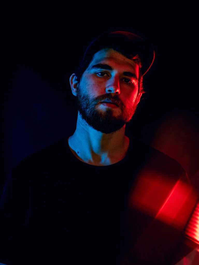 Cinematic studio portrait of independent music artist in red and blue light for branding photography