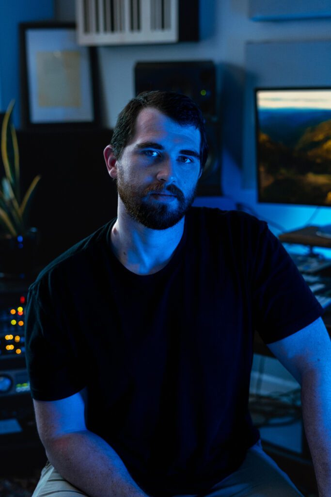 Cinematic blue portrait of musician in a custom-lit recording space