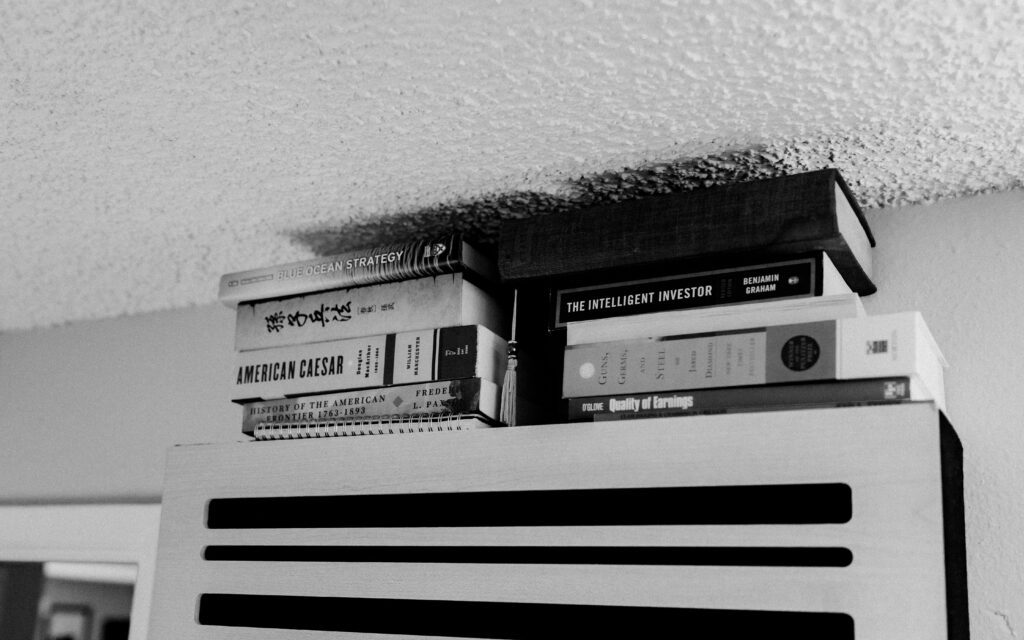Close-up arrangement of books styled on a minimalist producer’s shelf