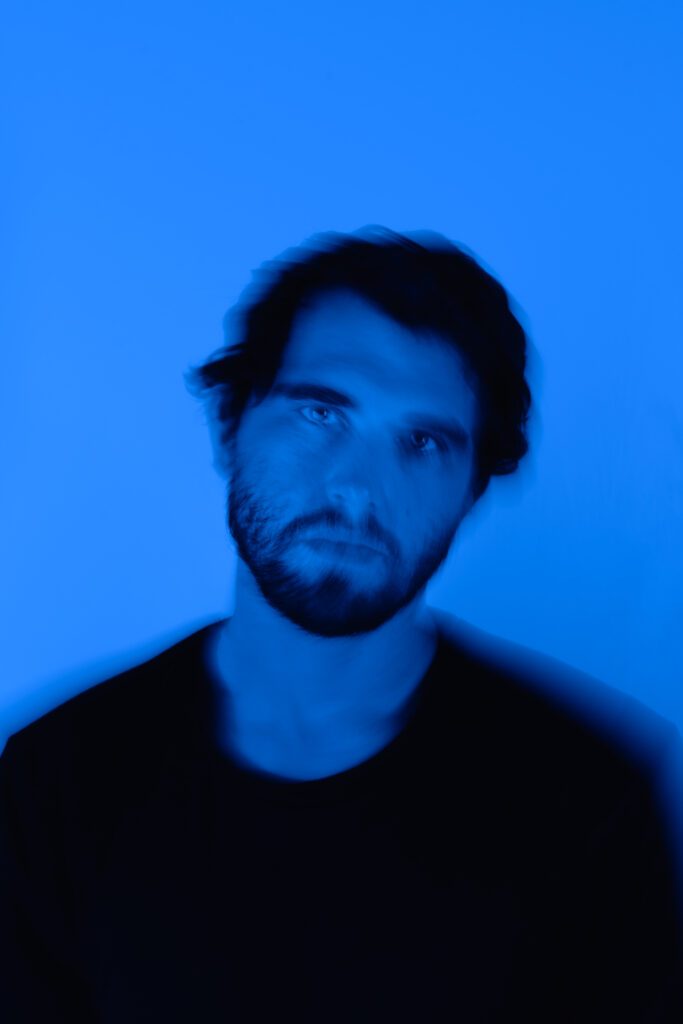 Moody artist headshot in vibrant blue tones for Spotify profile branding