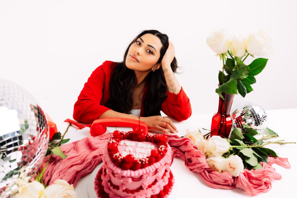 Creative Business Owner poses at a styled table featuring a cherry cake, disco balls, and white roses during her Speak Your Language session with Mewphotovideo