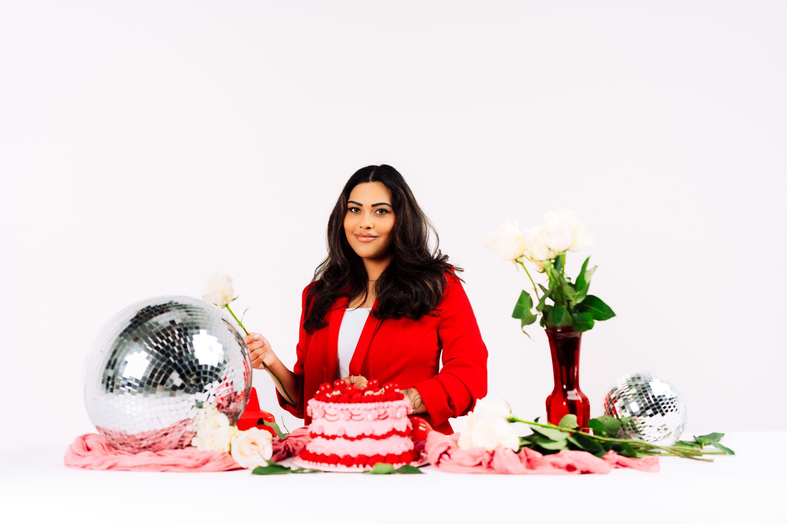 Creative Agency Rose & Salt Social poses with a red and pink birthday cake and bold branding elements during a Speak Your Language brand photo session with Mewphotovideo in Portland.